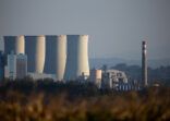 Black coal-fired power plant seen from a distance. No smoke coming out from the chimneys.