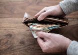 close-up of person counting stack of paper cash in wallet