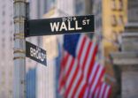 Wall Street Sign in New York With American Flags in the Background