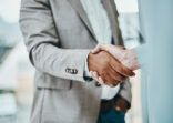 Shot of a businessman and businesswoman shaking hands in a modern office