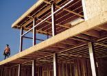 Man standing on house under construction