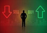 silhouette trader standing looking at stock market chart with buy and sell symbol